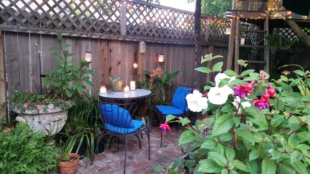 Example of a mid-sized classic backyard brick patio container garden design in Los Angeles with an awning