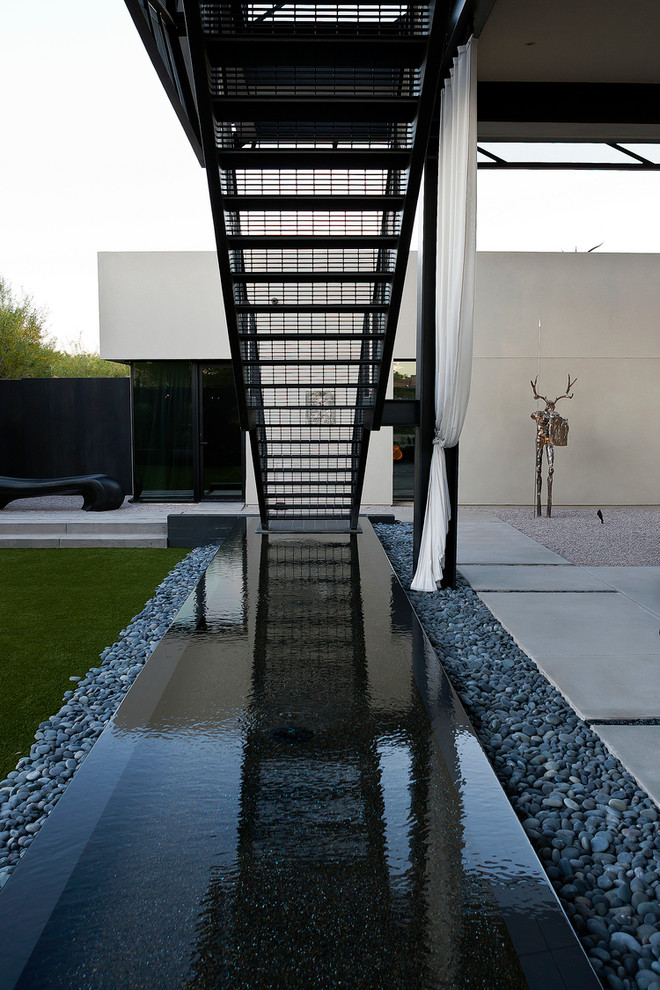 Стильный дизайн: большой двор на заднем дворе в современном стиле с покрытием из бетонных плит, навесом и местом для костра - последний тренд