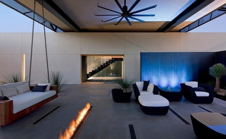 Esempio di un ampio patio o portico minimalista dietro casa con un focolare, lastre di cemento e un tetto a sbalzo