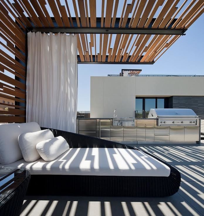 Immagine di un ampio patio o portico minimalista dietro casa con pavimentazioni in cemento e una pergola