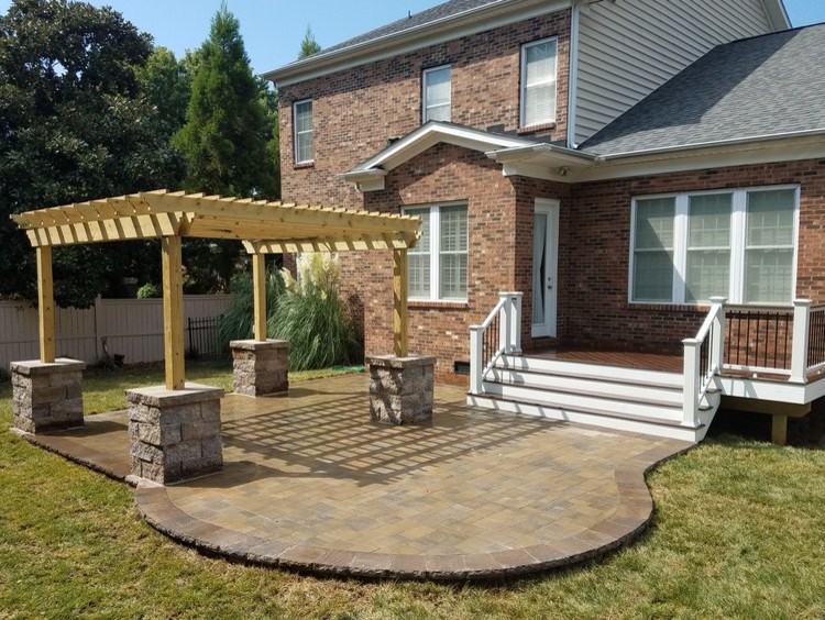 Mid-sized transitional backyard brick patio photo in Charlotte with a pergola