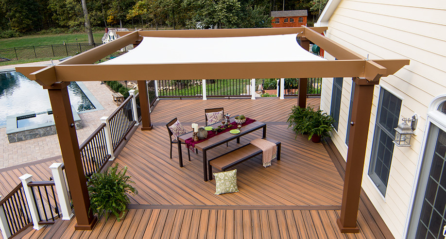 Modelo de terraza actual de tamaño medio en patio trasero con cocina exterior y pérgola