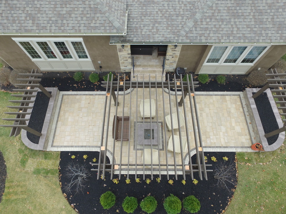 Aménagement d'une terrasse arrière contemporaine de taille moyenne avec un foyer extérieur, des pavés en béton et une pergola.