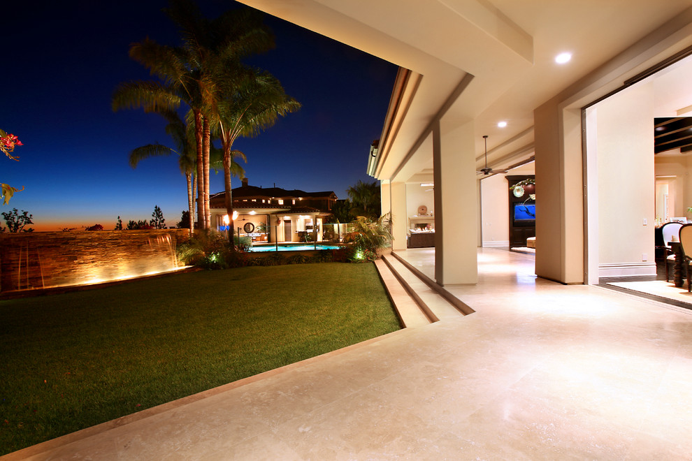 На фото: большой двор на заднем дворе в средиземноморском стиле с покрытием из декоративного бетона и навесом