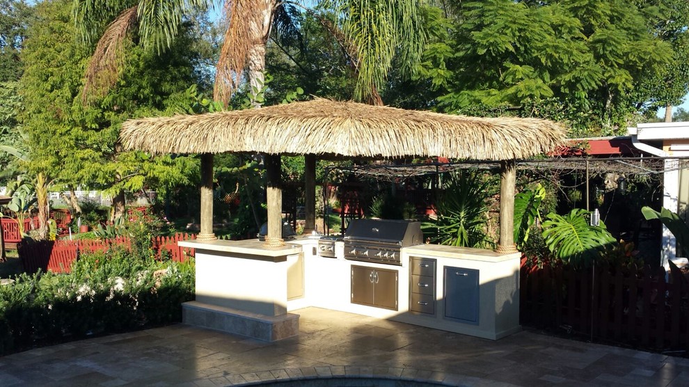 Ejemplo de patio tropical extra grande sin cubierta en patio trasero con cocina exterior