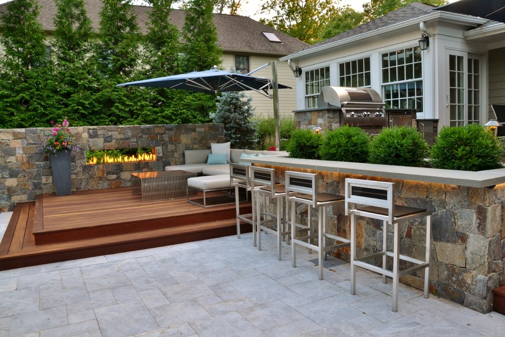 Design ideas for a small world-inspired back patio in New York with an outdoor kitchen and natural stone paving.