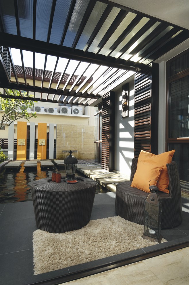 Photo of a world-inspired patio in Other with a water feature and a pergola.