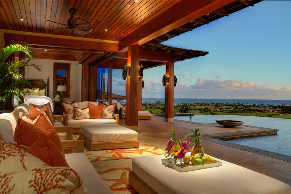Expansive world-inspired back patio in Hawaii with tiled flooring and a roof extension.