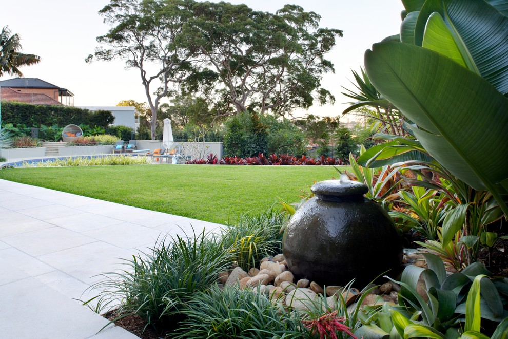 Ejemplo de jardín contemporáneo grande en patio trasero con adoquines de piedra natural