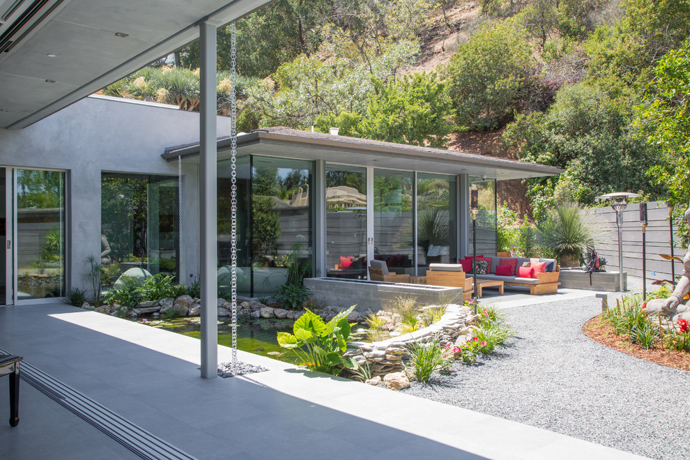 ロサンゼルスにあるコンテンポラリースタイルのおしゃれな裏庭のテラス (コンクリート板舗装	、張り出し屋根) の写真