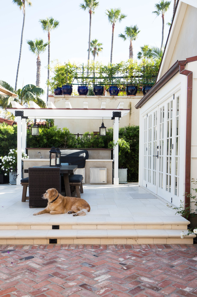 Inspiration for a large traditional back patio in San Diego with an outdoor kitchen, natural stone paving and no cover.