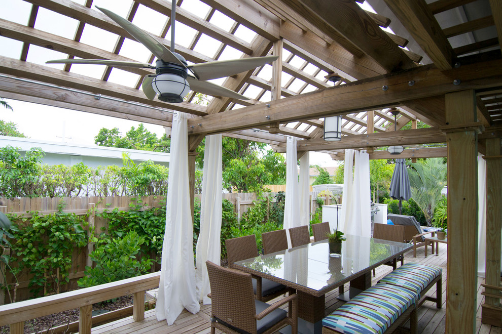 Mid-sized island style side yard patio photo in Miami with decking and a pergola