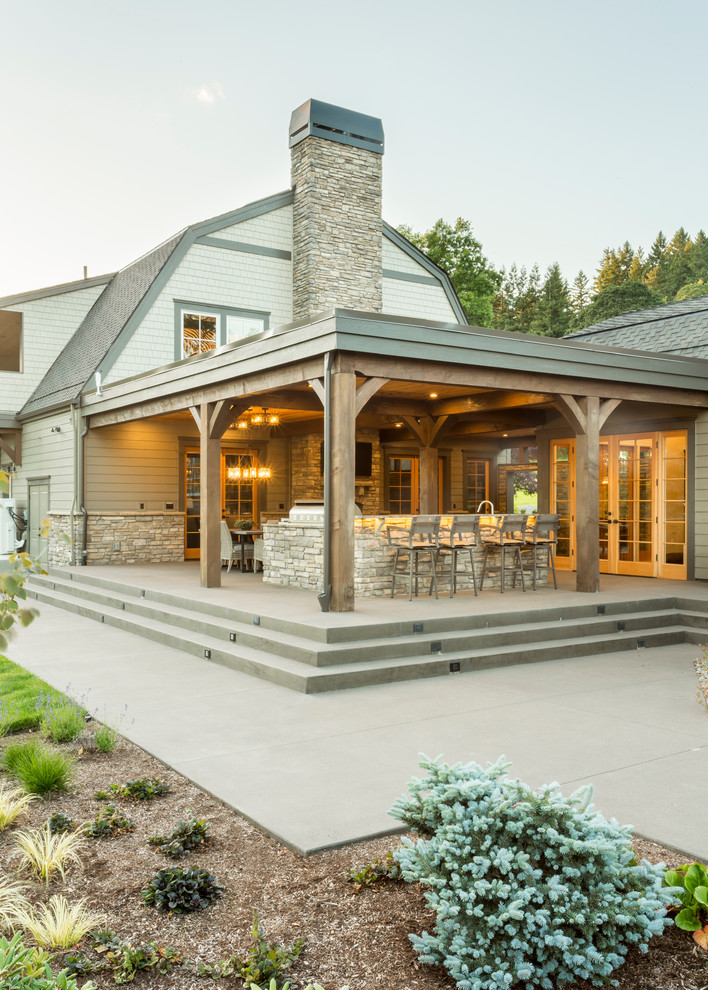 Expansive rustic back patio in Portland with an outdoor kitchen, concrete slabs and a roof extension.