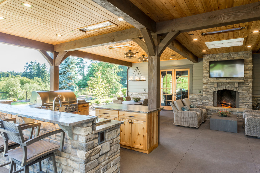 Cette photo montre une très grande terrasse arrière montagne avec une cuisine d'été, une dalle de béton et une extension de toiture.