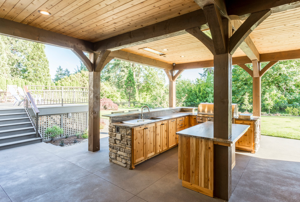 Пример оригинального дизайна: огромный двор на заднем дворе в стиле рустика с летней кухней, покрытием из бетонных плит и навесом