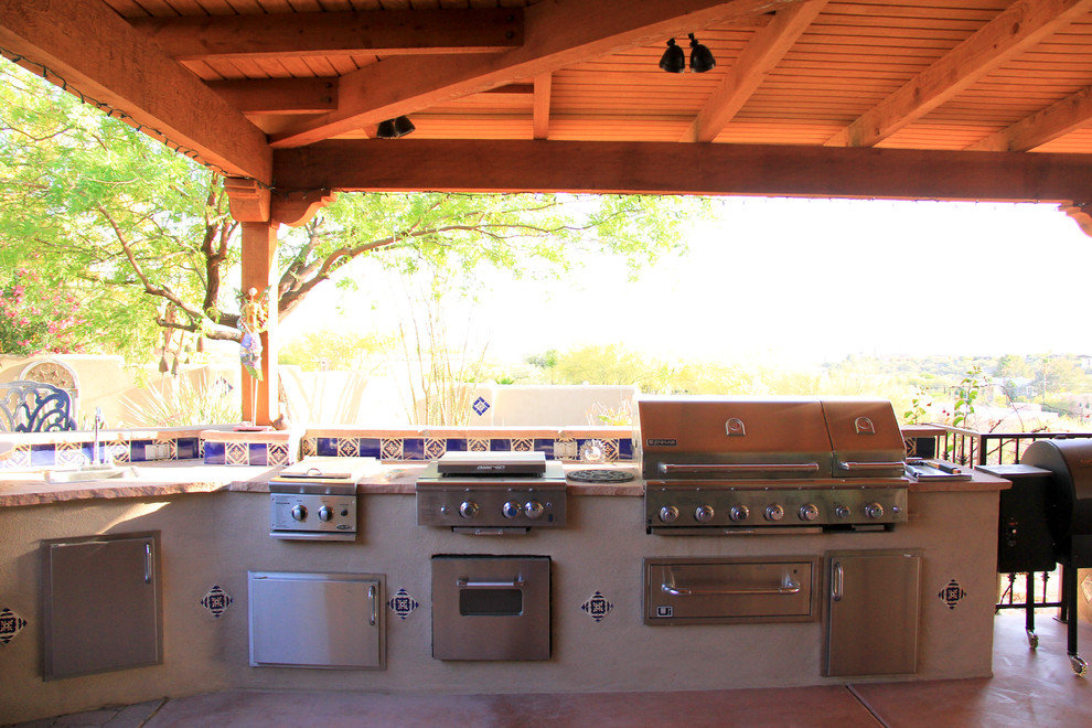 Medium sized mediterranean back patio in Phoenix with an outdoor kitchen, concrete slabs and a roof extension.