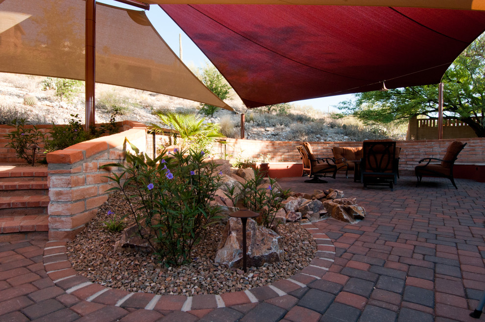 Inspiration for a medium sized back patio in Phoenix with brick paving and an awning.