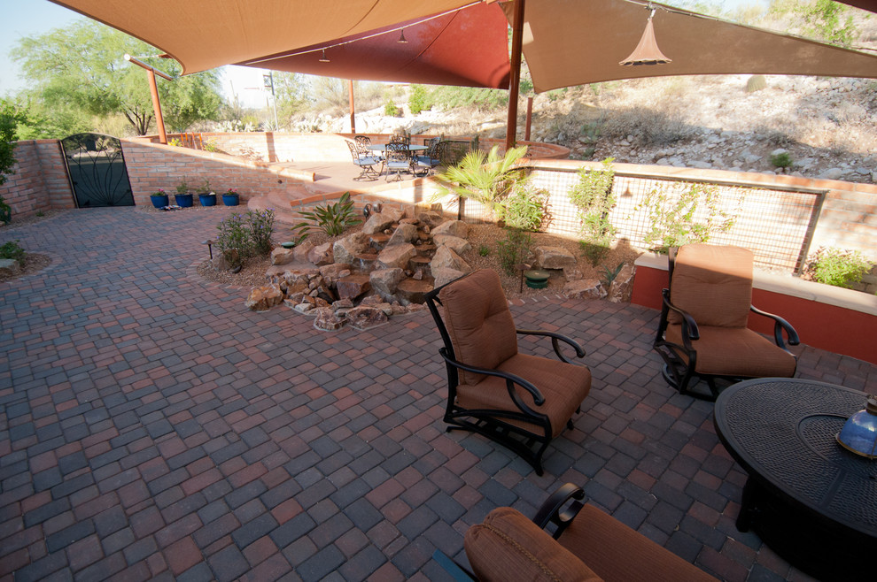 Inspiration for a mid-sized southwestern backyard brick patio remodel in Phoenix with an awning