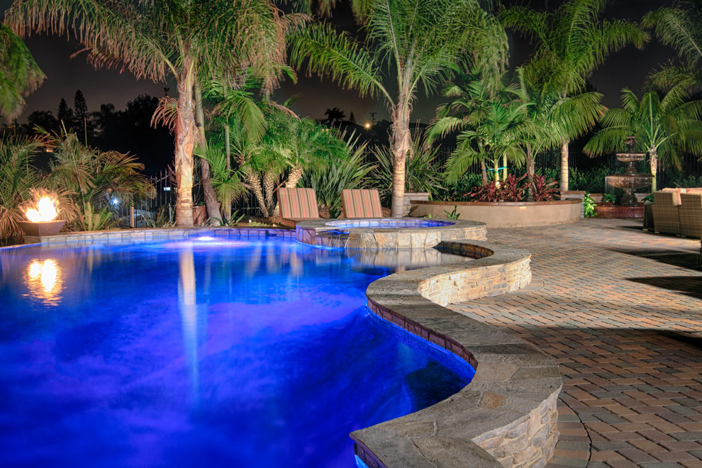 Großer Klassischer Pool hinter dem Haus mit Wasserspiel und Betonboden in San Diego