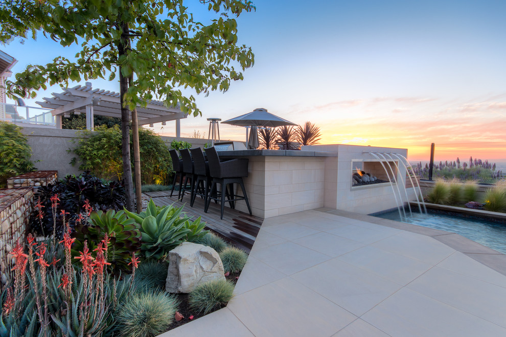 Example of a mid-sized trendy backyard patio design in Orange County with a fire pit, decking and no cover