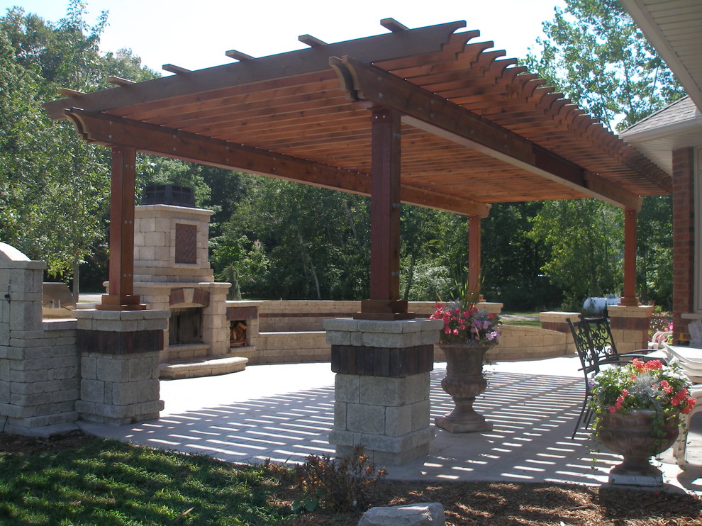 Design ideas for a large traditional back patio in Toronto with a fire feature, natural stone paving and a pergola.