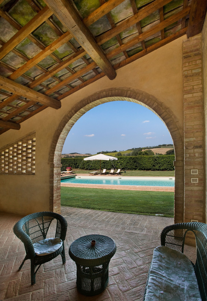 Immagine di un patio o portico mediterraneo con un tetto a sbalzo