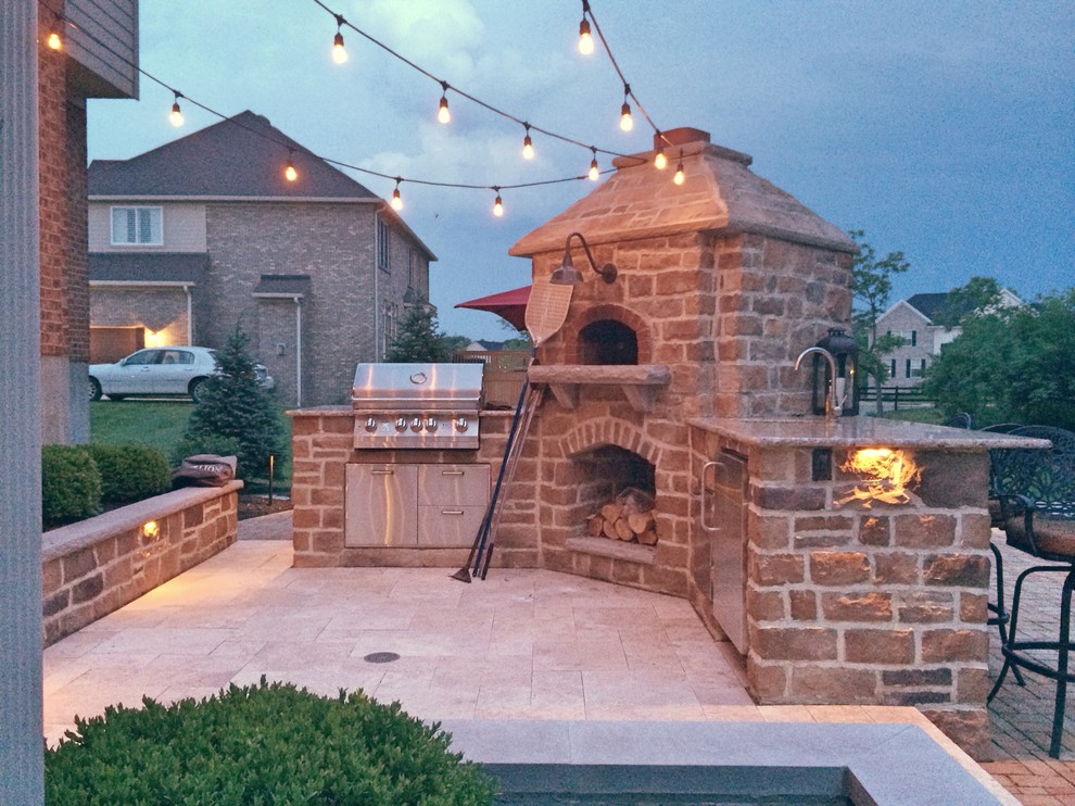 Inspiration pour une terrasse arrière chalet de taille moyenne avec une cuisine d'été, des pavés en pierre naturelle et une extension de toiture.