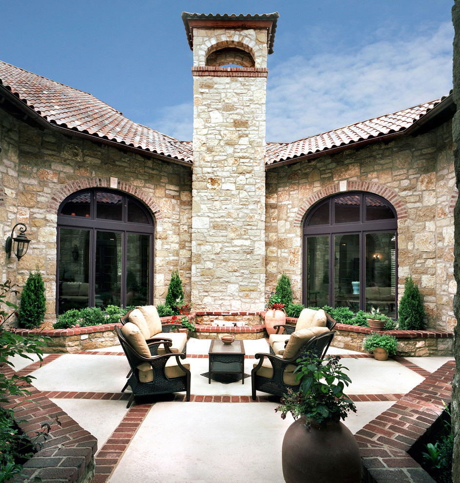 Photo of a large mediterranean courtyard patio in Kansas City with a fire feature, stamped concrete and no cover.