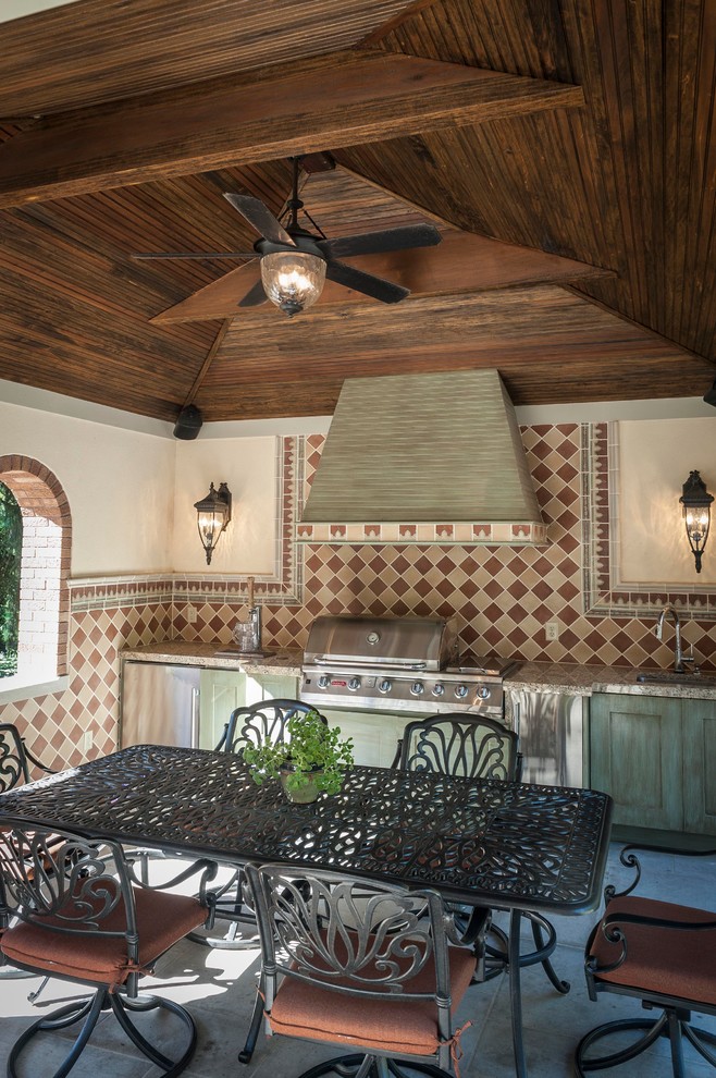 Cette photo montre une grande terrasse arrière méditerranéenne avec une cuisine d'été, des pavés en pierre naturelle et un gazebo ou pavillon.