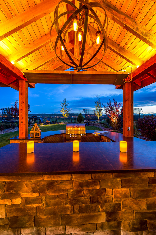 Mid-sized elegant backyard patio kitchen photo in Calgary with a pergola