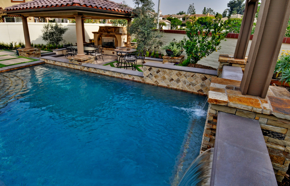 Photo of a medium sized mediterranean back rectangular above ground swimming pool in Orange County with concrete slabs and a pool house.
