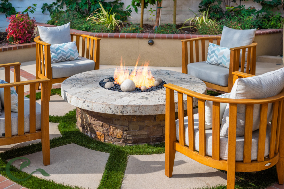 Mid-sized tuscan backyard concrete paver patio photo in Orange County with a fire pit and a gazebo