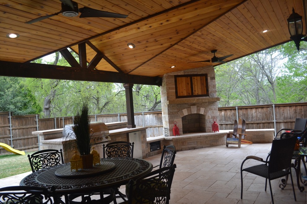 Photo of a large traditional back patio in Dallas with an outdoor kitchen, natural stone paving and a roof extension.
