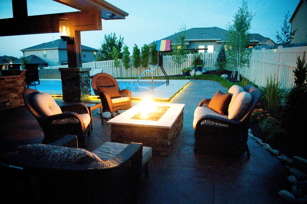 Immagine di un grande patio o portico tropicale dietro casa con lastre di cemento e una pergola