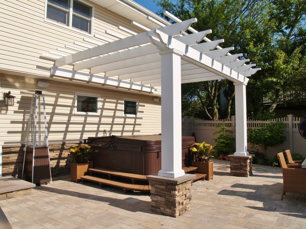 Immagine di un patio o portico american style di medie dimensioni e dietro casa con pavimentazioni in pietra naturale e una pergola