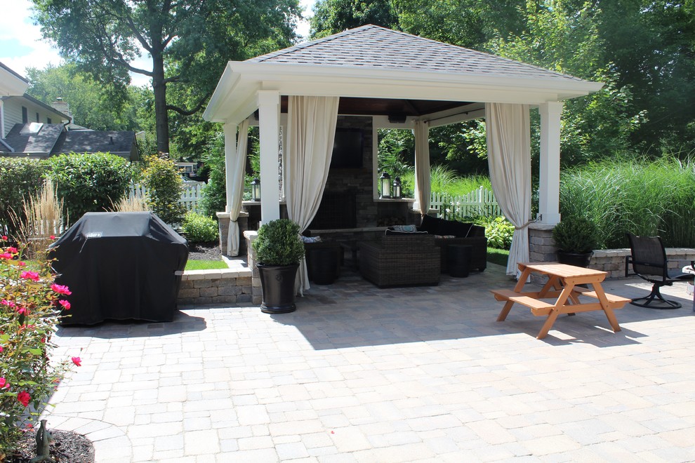 Example of a large classic backyard concrete paver patio design in Indianapolis with a fire pit and a gazebo
