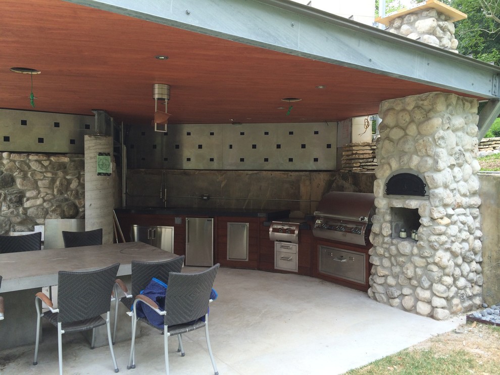 Modelo de patio moderno en anexo de casas y patio trasero con cocina exterior y losas de hormigón