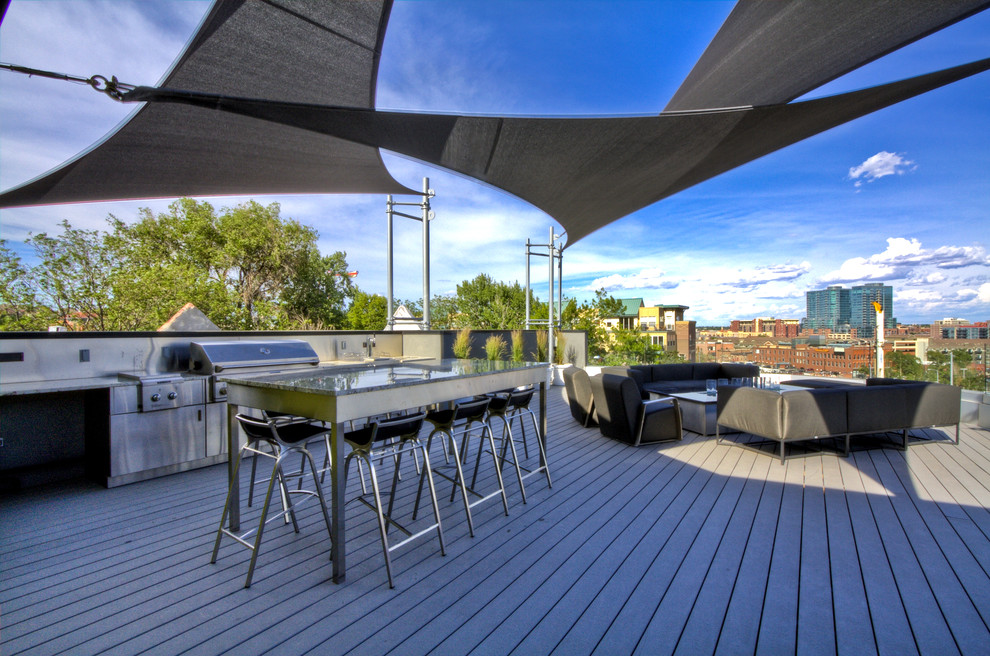Patio kitchen - large contemporary backyard patio kitchen idea in Denver with decking and an awning