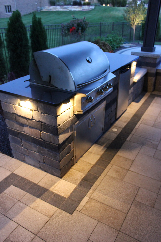Inspiration for a modern back patio in Chicago with an outdoor kitchen, brick paving and a gazebo.