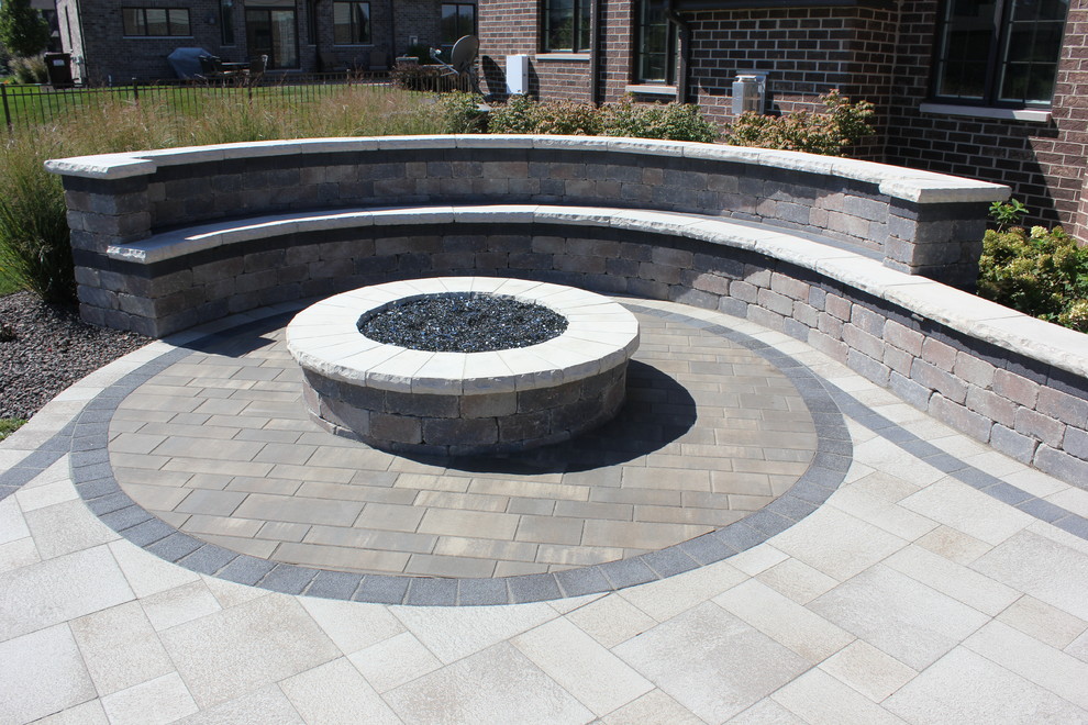 This is an example of a modern back patio in Chicago with a fire feature, brick paving and a gazebo.