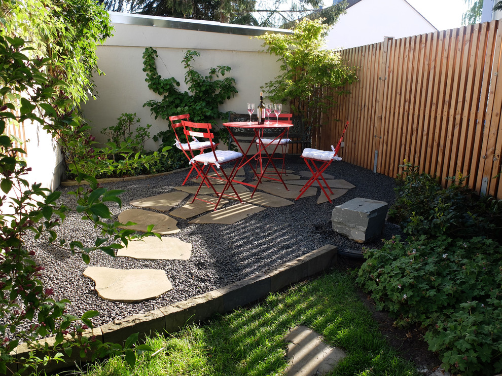 This is an example of a small retro back patio in Cologne with natural stone paving.