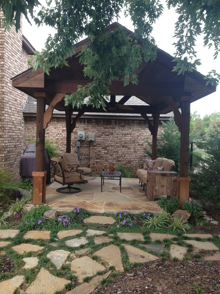 Foto di un patio o portico classico di medie dimensioni e dietro casa con pavimentazioni in pietra naturale e un gazebo o capanno