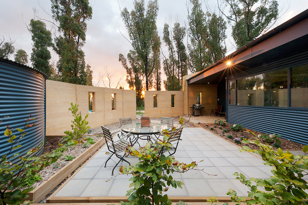 Diseño de patio actual de tamaño medio sin cubierta en patio trasero con adoquines de hormigón y huerto
