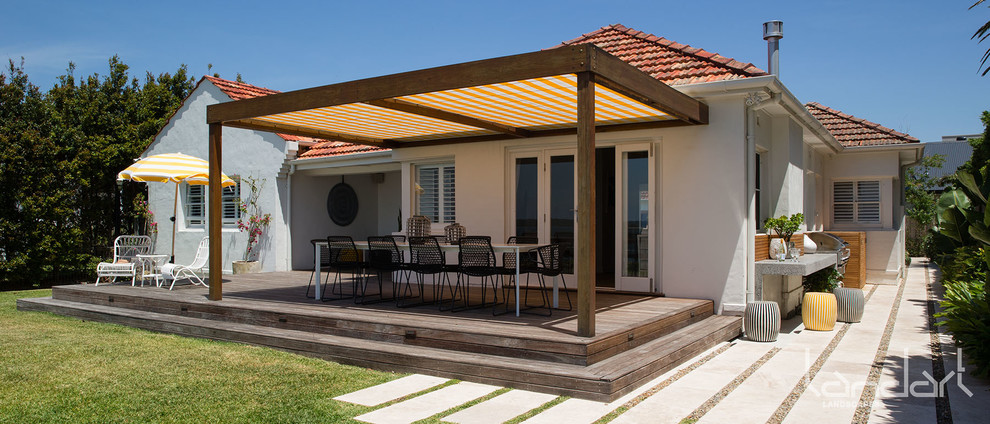 Exemple d'une terrasse en bois arrière tendance de taille moyenne avec une cuisine d'été et une pergola.
