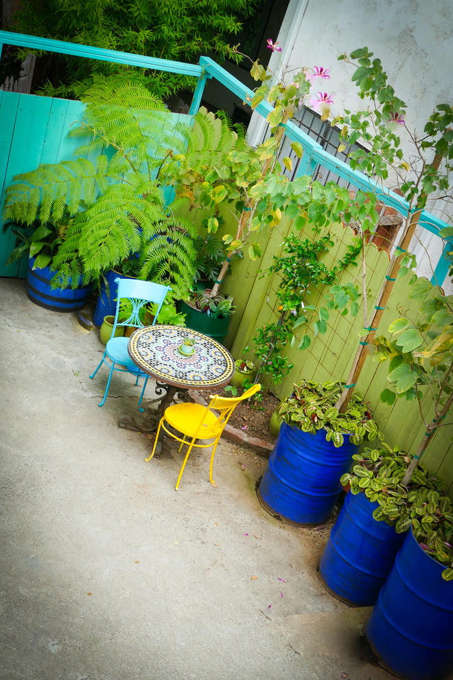 На фото: двор на боковом дворе в морском стиле с растениями в контейнерах и покрытием из бетонных плит без защиты от солнца с