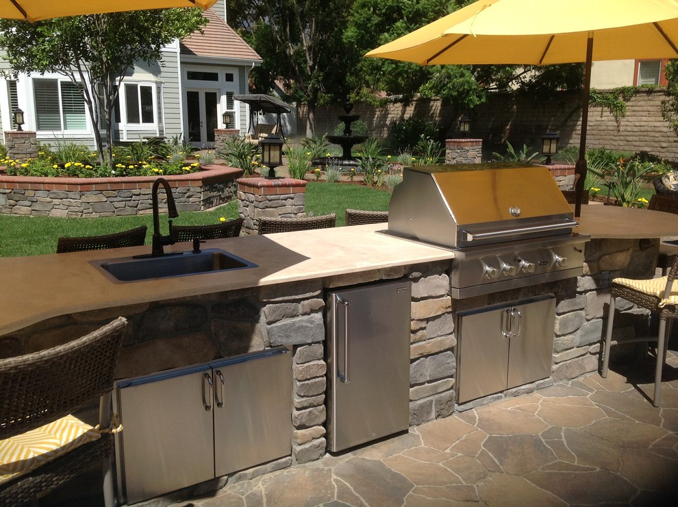Inspiration for a large timeless backyard stone patio kitchen remodel in Los Angeles