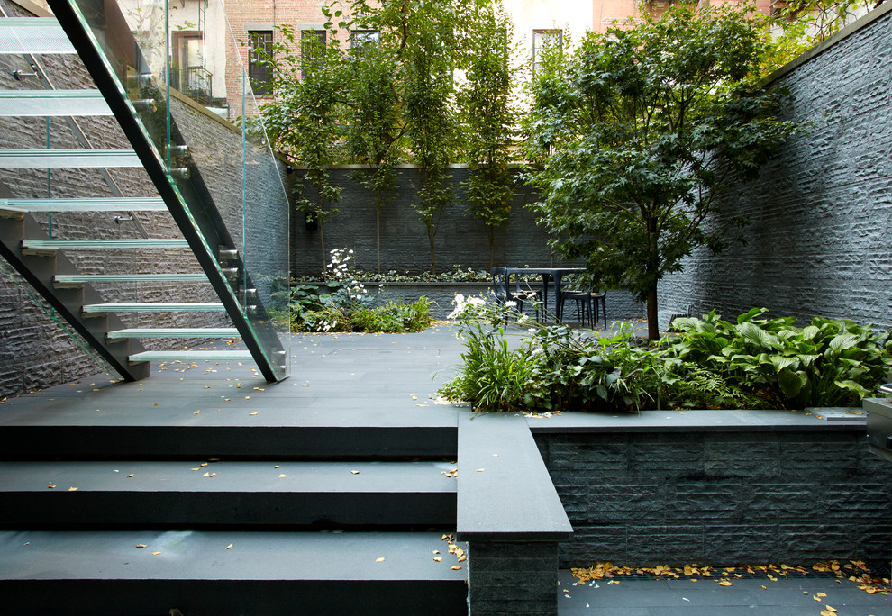 Idée de décoration pour une grande terrasse minimaliste avec une cour, du carrelage et aucune couverture.