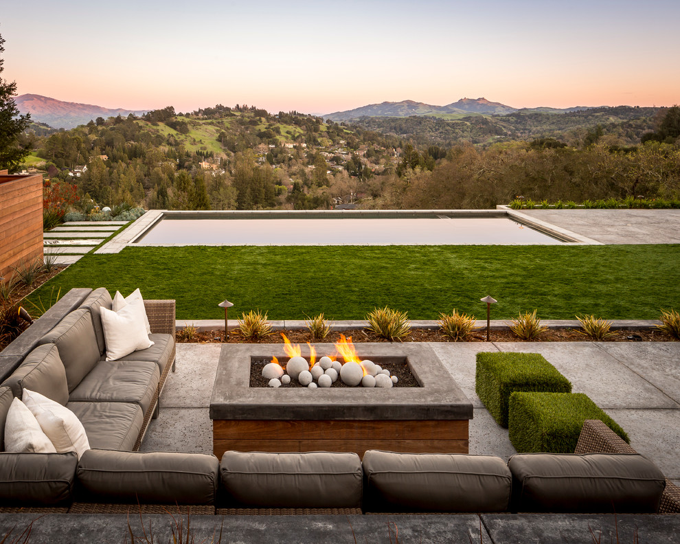 This is an example of a contemporary patio in San Francisco with a fire feature, concrete slabs and no cover.