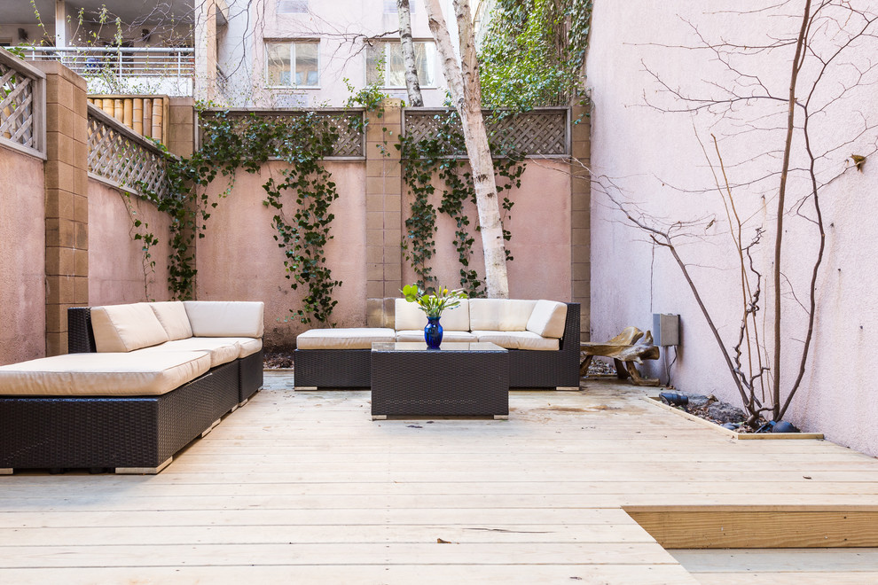 Inspiration for a large modern back patio in New York with decking and no cover.