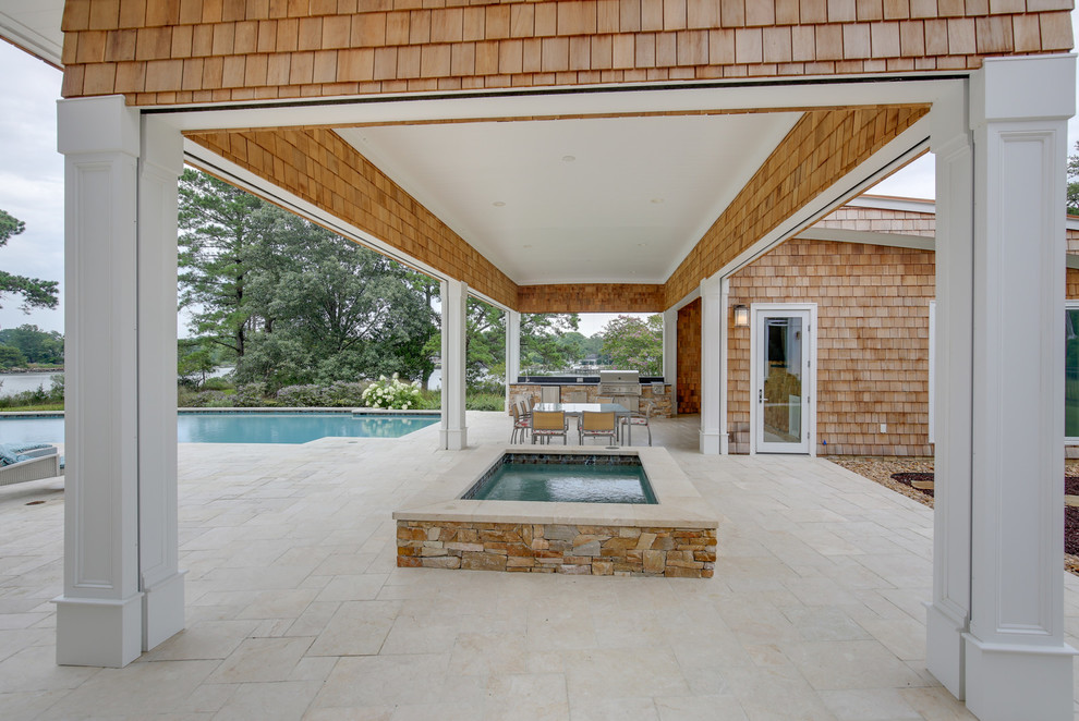 Idée de décoration pour une grande terrasse arrière design avec une cuisine d'été, des pavés en pierre naturelle et une extension de toiture.